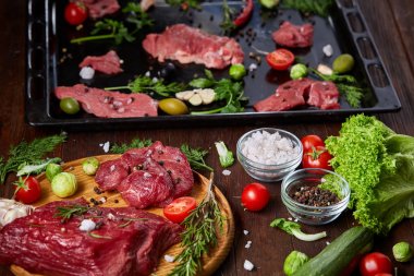 Natürmort ham sığır eti antika arka plan, üstten görünüm, seçici odak ahşap plaka üzerinde sebzeli