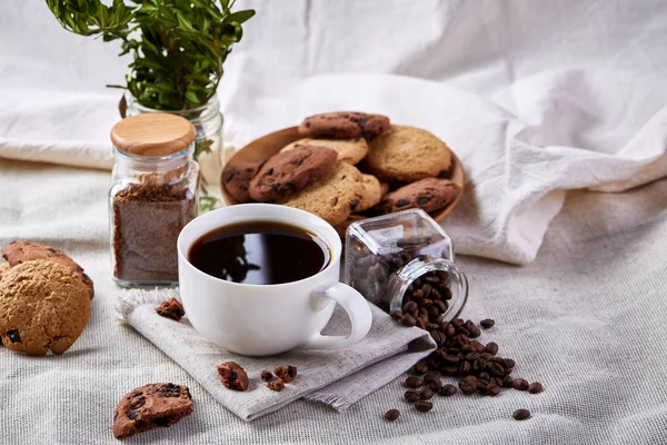 Кофейная чашка, банка с кофейными зёрнами, печенье на белом столе избирательный фокус, крупный план, вид сверху — стоковое фото