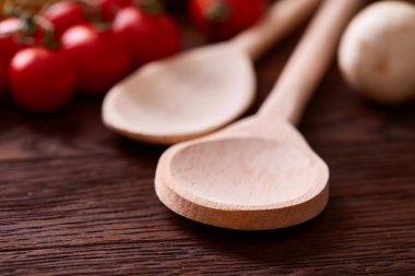 Domates ve mantar üzerine sığ derinlik-in tarla rustik ahşap arka plan arasında iki tahta kaşıklar