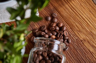 Kavrulmuş kahve çekirdekleri devrilmiş Cam Kavanoz saf masa örtüsü, seçici odak, yan görünüm elde