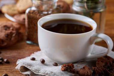 Kahve fincanı, kavanoz kahve çekirdekleri, Çerezler üzerinde rustik arka plan, seçici odak, yakın çekim, en iyi görünümü ile