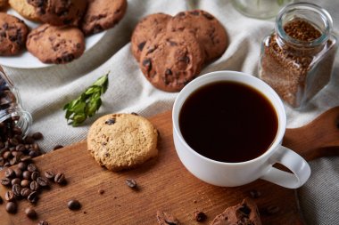 Kahve fincanı, kavanoz kahve çekirdekleri, Çerezler üzerinde rustik arka plan, seçici odak, yakın çekim, en iyi görünümü ile