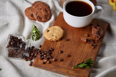 Kahve fincanı, kavanoz kahve çekirdekleri, Çerezler üzerinde rustik arka plan, seçici odak, yakın çekim, en iyi görünümü ile