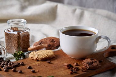 Kahve fincanı, kavanoz kahve çekirdekleri, Çerezler üzerinde rustik arka plan, seçici odak, yakın çekim, en iyi görünümü ile