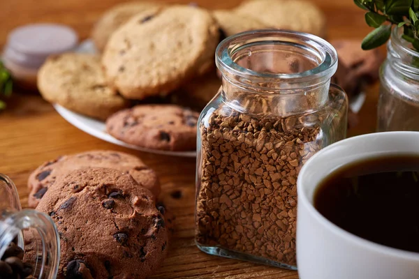 Kaffeetasse, Glas mit Kaffeebohnen, Kekse vor rustikalem Hintergrund, selektiver Fokus, Nahaufnahme, Draufsicht — Stockfoto