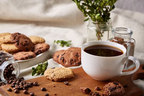 Taza de café, frasco con granos de café, galletas sobre fondo rústico, enfoque selectivo, primer plano, vista superior — Foto de Stock