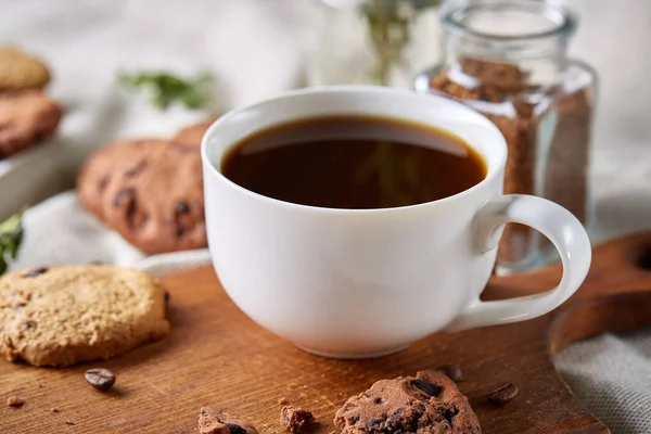 Kaffeetasse, Glas mit Kaffeebohnen, Kekse vor rustikalem Hintergrund, selektiver Fokus, Nahaufnahme, Draufsicht — Stockfoto