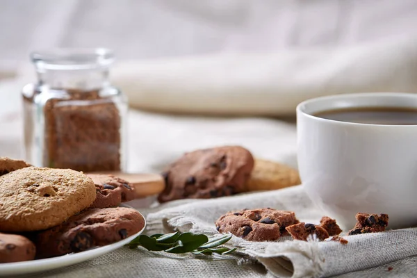 Morning coffee in white cup, chocolate chips cookies on cutting board close-up, selective focus — Stock Photo, Image