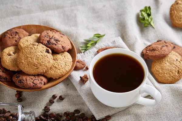 Café da manhã na xícara branca, biscoitos de chocolate na placa de corte close-up, foco seletivo — Fotografia de Stock