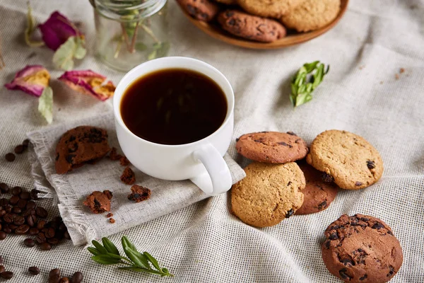 Breakfast background with mug of fresh coffee, homemade oatmeal cookies, grind coffee