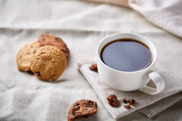 Breakfast background with mug of fresh coffee, homemade oatmeal cookies, grind coffee