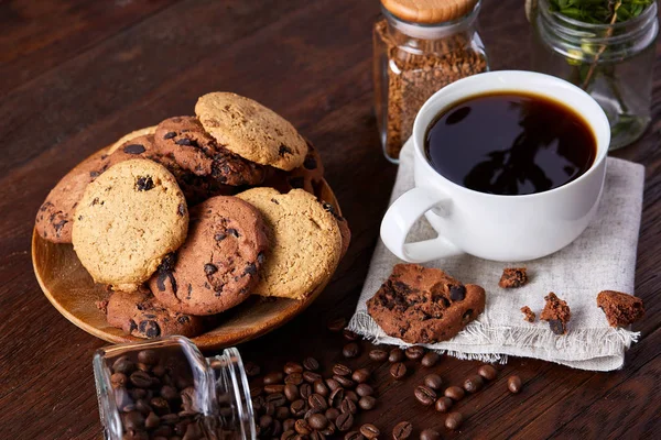 Vista lateral de uma placa de biscoitos de chocolate em uma placa branca na toalha de mesa caseira, foco seletivo — Fotografia de Stock