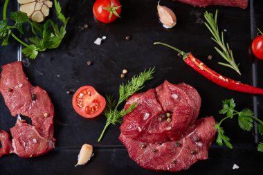 Sebzeler, otlar ve metal tepsi, yakın çekim, seçici odak spicies çiğ biftek düz lay