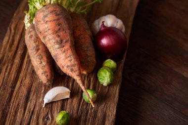 Havuç toprak rustik ahşap arka plan, yan görünüm, yakın çekim, seçici odak, düşük anahtar ile demet