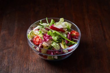 Cam kasede servis koyu ahşap arka plan, seçici odak, sığ derinlik-in tarla üzerinde taze sebze salatası