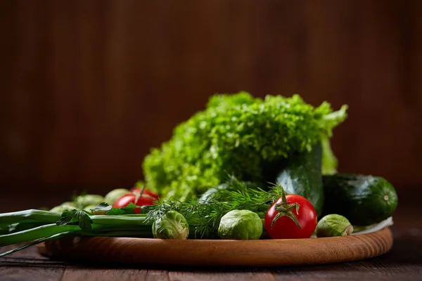 Vegetariano ainda vida de legumes frescos em placa de madeira sobre fundo rústico, close-up, flat lay . — Fotografia de Stock