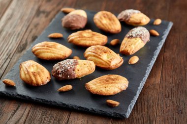 Fırından yeni çıkmış taş gemide badem badem kurabiye ahşap arka plan, üstten görünüm, seçici odak üzerinde.