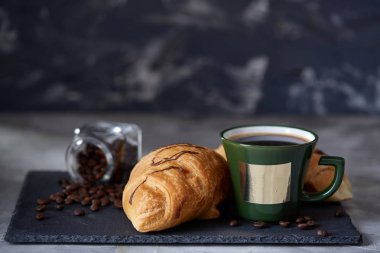 Kahve fincanı, kavanoz kahve çekirdekleri, beyaz arka plan, seçici odak, yakın çekim taş gemide kruvasan ile