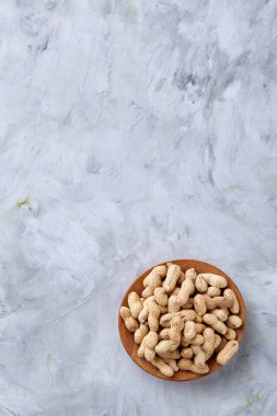 Ahşap plaka üzerinde beyaz dokulu arka plan closeup, seçici odak soyulmamış fıstık