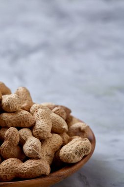 Ahşap plaka üzerinde beyaz dokulu arka plan closeup, seçici odak soyulmamış fıstık