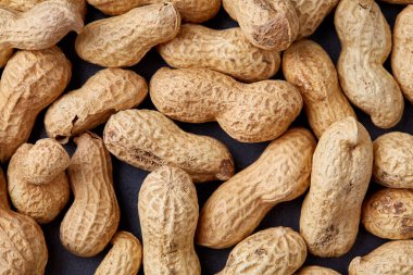 Tepsi üzerinde beyaz ekmek üzerinde soyulmamış çiğ fıstık dokulu arka plan, seçici odak, sığ derinlik-in tarla.