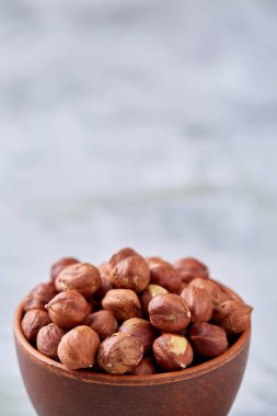 Kopya alanı, üstten görünüm, seçici odak wihite zemin üzerine seramik kase fındık.