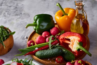 Yaratıcı taze sebze salatası ruccola, salatalık, domates ve beyaz plaka, seçici odak üzerinde raddish