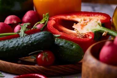 Yaratıcı taze sebze salatası ruccola, salatalık, domates ve beyaz plaka, seçici odak üzerinde raddish