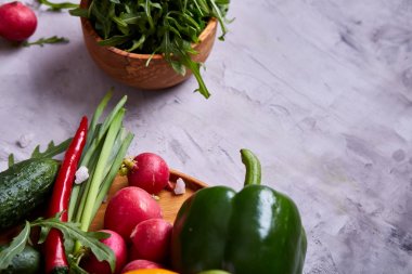 Yaratıcı taze sebze salatası ruccola, salatalık, domates ve beyaz plaka, seçici odak üzerinde raddish