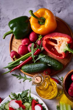 Yaratıcı taze sebze salatası ruccola, salatalık, domates ve beyaz plaka, seçici odak üzerinde raddish