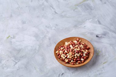 Ahşap plaka izole beyaz dokulu arka plan, üstten görünüm, yakın çekim üzerinde ham karışık fıstık.