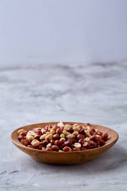 Ahşap plaka izole beyaz dokulu arka plan, üstten görünüm, yakın çekim üzerinde ham karışık fıstık.