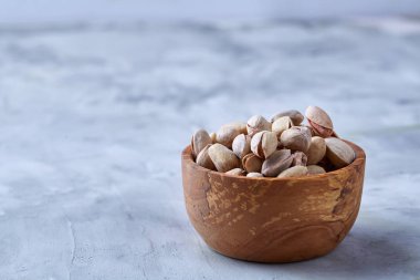 Beyaz arka plan, üstten görünüm, yakın çekim, seçici odak ahşap bir tabakta tuzlu fıstık.