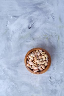 Beyaz arka plan, üstten görünüm, yakın çekim, seçici odak ahşap bir tabakta tuzlu fıstık.