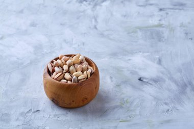 Beyaz arka plan, üstten görünüm, yakın çekim, seçici odak ahşap bir tabakta tuzlu fıstık.