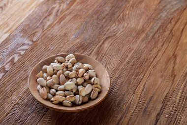 Ahşap arka plan, üstten görünüm, yakın çekim, seçici odak ahşap bir tabakta tuzlu fıstık.