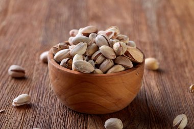 Ahşap arka plan, üstten görünüm, yakın çekim, seçici odak ahşap bir tabakta tuzlu fıstık.