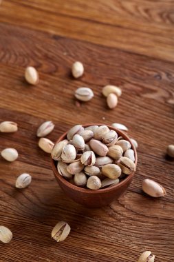 Ahşap arka plan, üstten görünüm, yakın çekim, seçici odak ahşap bir tabakta tuzlu fıstık.