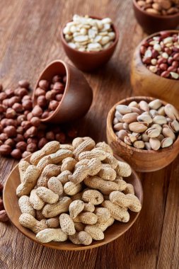 Bir kompozisyon farklı rustik arka plan, yakın çekim, sığ derinlik-in tarla ahşap bir kase içinde fındık çeşitleri