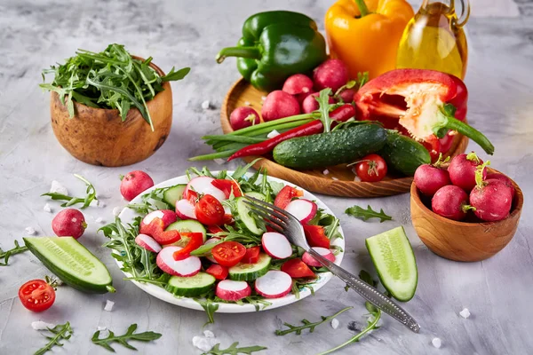 Salada de legumes frescos criativos com ruccola, pepino, tomate e rabdish na placa branca, foco seletivo — Fotografia de Stock