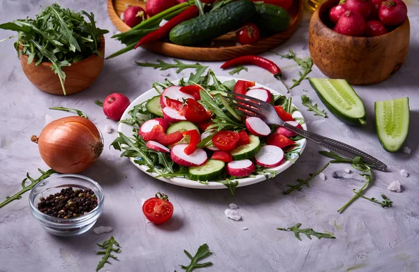 Frischer roter Rettich in Holzschale zwischen Tellern mit Gemüse, Kräutern und Gewürzen, Draufsicht, selektiver Fokus. — Stockfoto