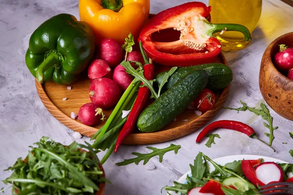 Creative sałatką ze świeżych warzyw z ruccola, ogórek, pomidory i raddish na białym talerzu, Selektywny fokus — Zdjęcie stockowe