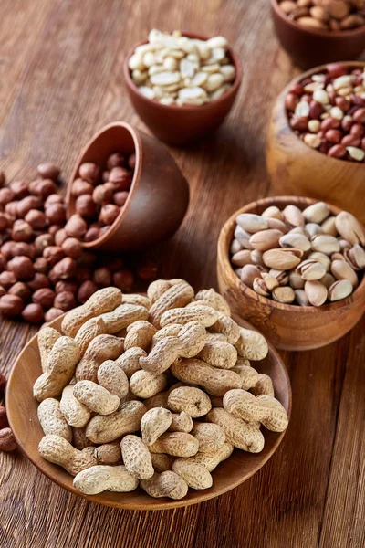 Bir kompozisyon farklı rustik arka plan, yakın çekim, sığ derinlik-in tarla ahşap bir kase içinde fındık çeşitleri