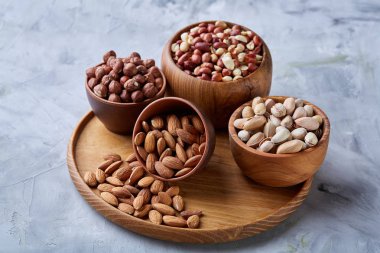 Beyaz arka plan, yakın çekim, en iyi görünüm, seçici odak ahşap tepsi üzerinde kahverengi kase karışık Kuruyemiş.