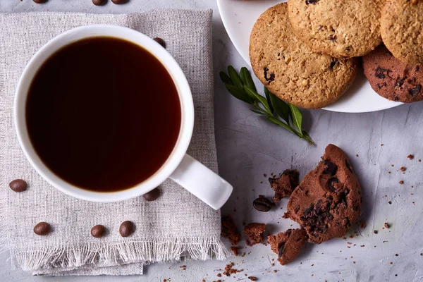 Morning coffee in white cup, chocolate chips cookies on homespun napkin, close-up, selective focus — Stock Photo, Image