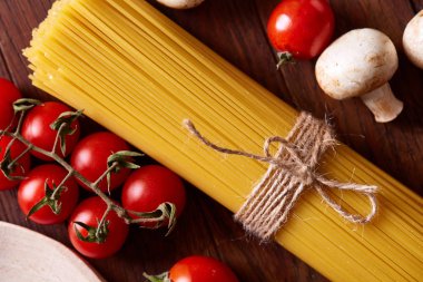 Pişmemiş makarna, domates ahşap arka plan, üstten görünüm, yakın çekim, seçici odak