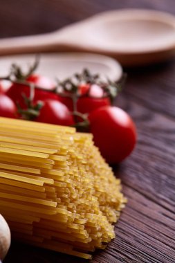 Pişmemiş makarna, domates ahşap arka plan, üstten görünüm, yakın çekim, seçici odak