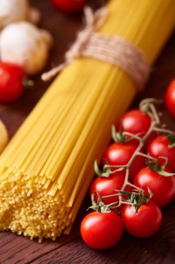 Pişmemiş makarna, domates ahşap arka plan, üstten görünüm, yakın çekim, seçici odak