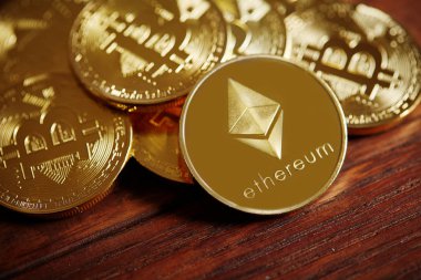 Cryptocurrencies yığını üzerinde ahşap masa yerleştirilir. Ethereum en önemli cryptocurrency kavram olarak.