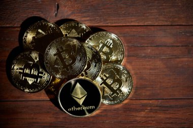 Cryptocurrencies yığını üzerinde ahşap masa yerleştirilir. Ethereum en önemli cryptocurrency kavram olarak.